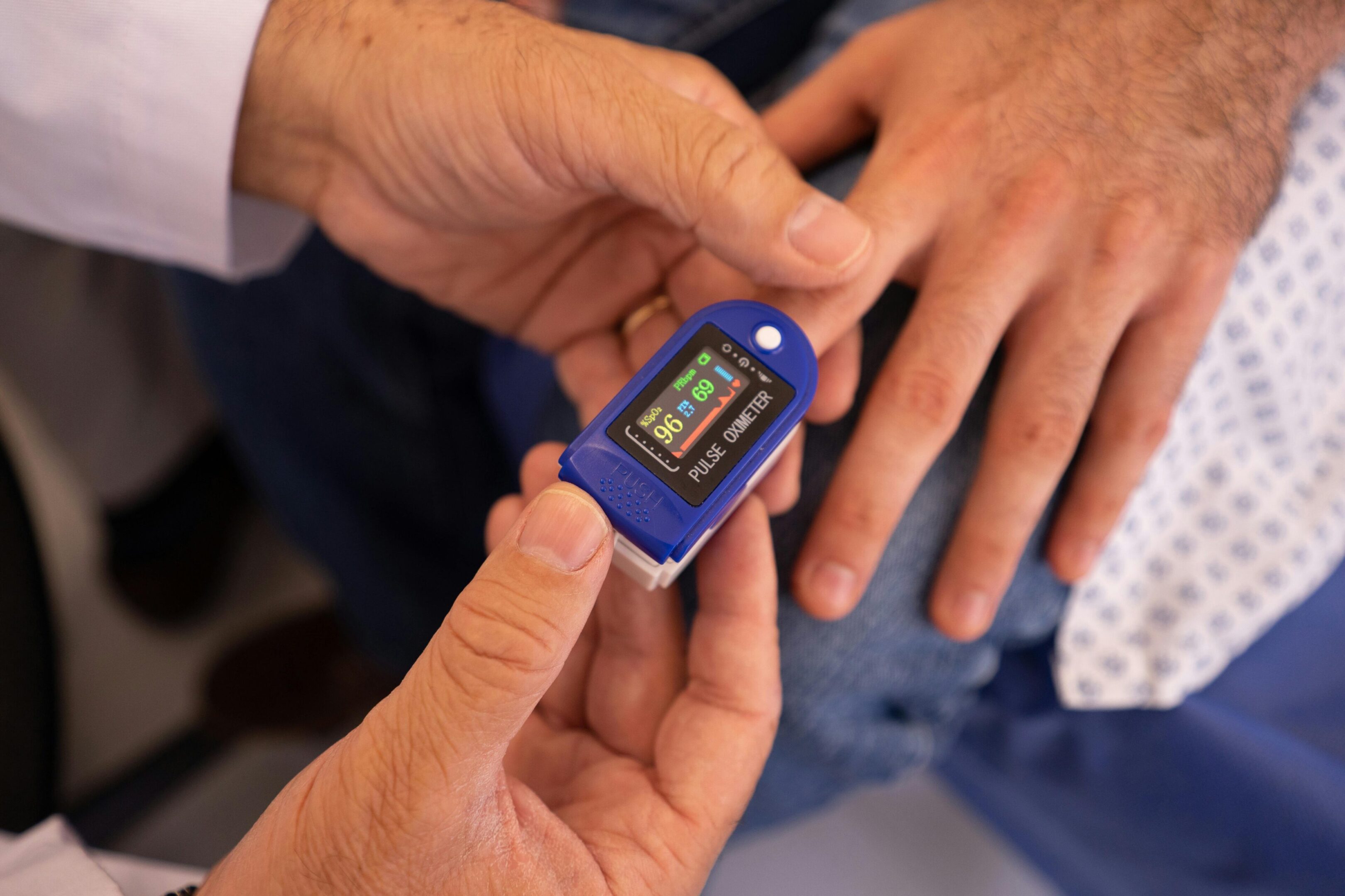 Person using a fingertip pulse oximeter to check oxygen levels.